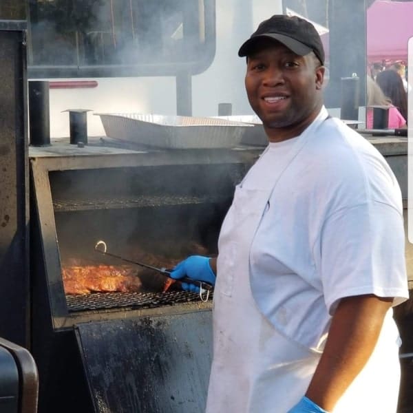 Social Que BBQ & Catering's Owner, Brealon, smoking meat at an event